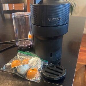 Nespresso Black Coffee Machine with Orange and Silver Capsules